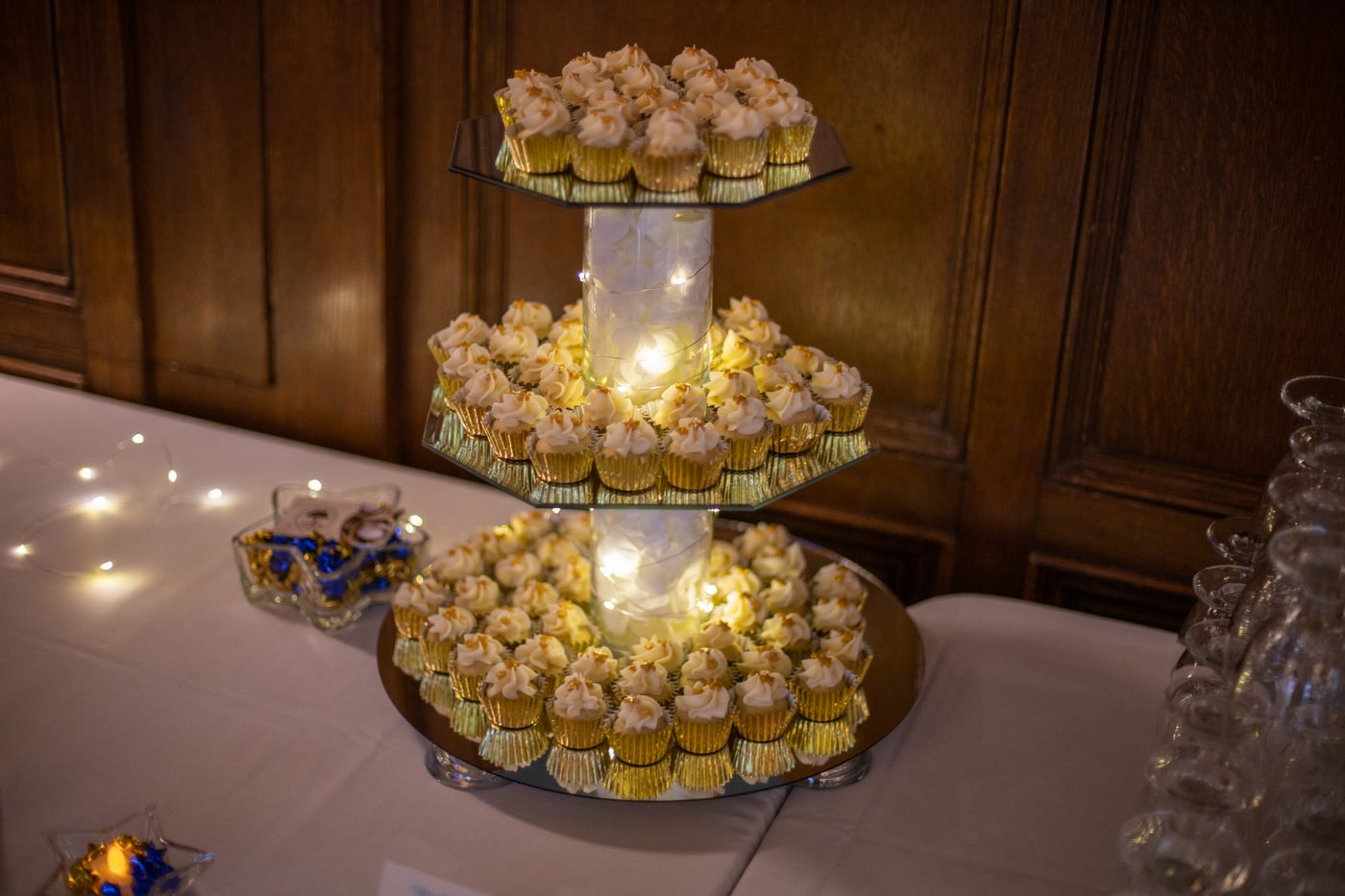Three-tier gold cupcake tower with fresh flowers, from a recent wedding