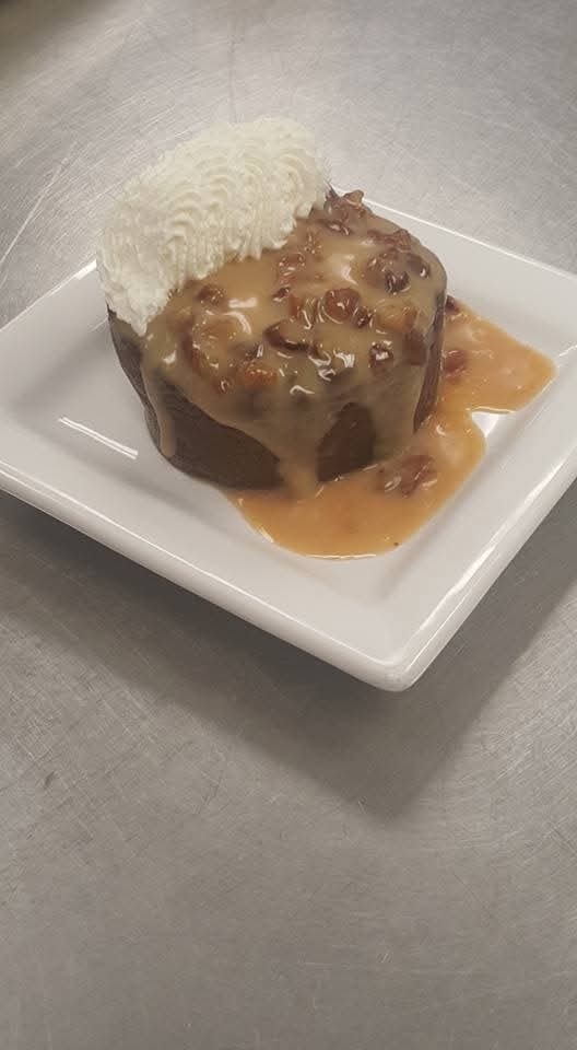 Sticky toffee pudding cake with caramel sauce and whipped cream