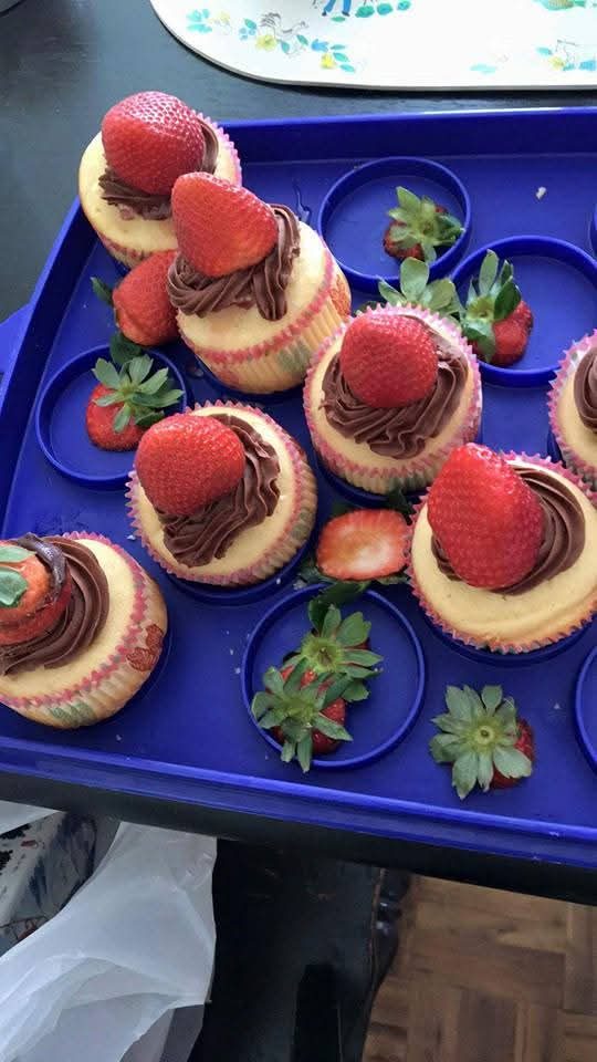 Cupcakes topped with chocolate hazelnut frosting and fresh strawberries