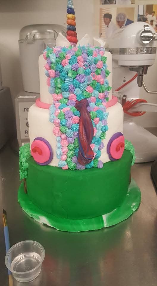 Three-tier unicorn cake with a rainbow horn and fondant flowers